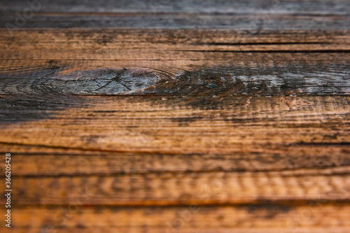 A wooden table, an element of an old table with a knot, the near and background are blurred.
