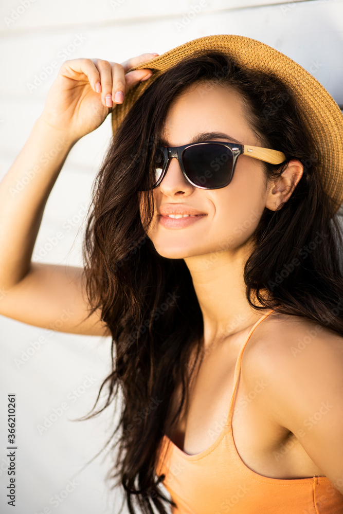 Pretty brunette girl in a straw hat posing for the camera Pretty brunette girl in a straw hat posing for the camera