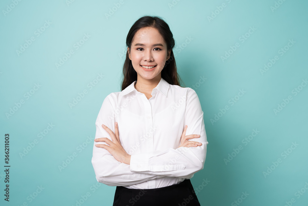 Portrait of young asian woman crossing arms and smile on blue background. Portrait of young asian woman crossing arms and smile on blue background.