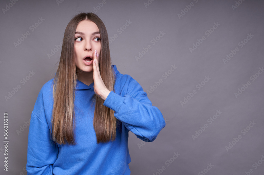 A young surprised girl tells the secret, the news. A young surprised girl tells the secret, the news.