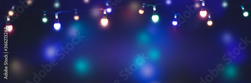 bunte lichterketten in einer reihe in der nacht, magischer hintergrund banner für feiertage mit werbefläche