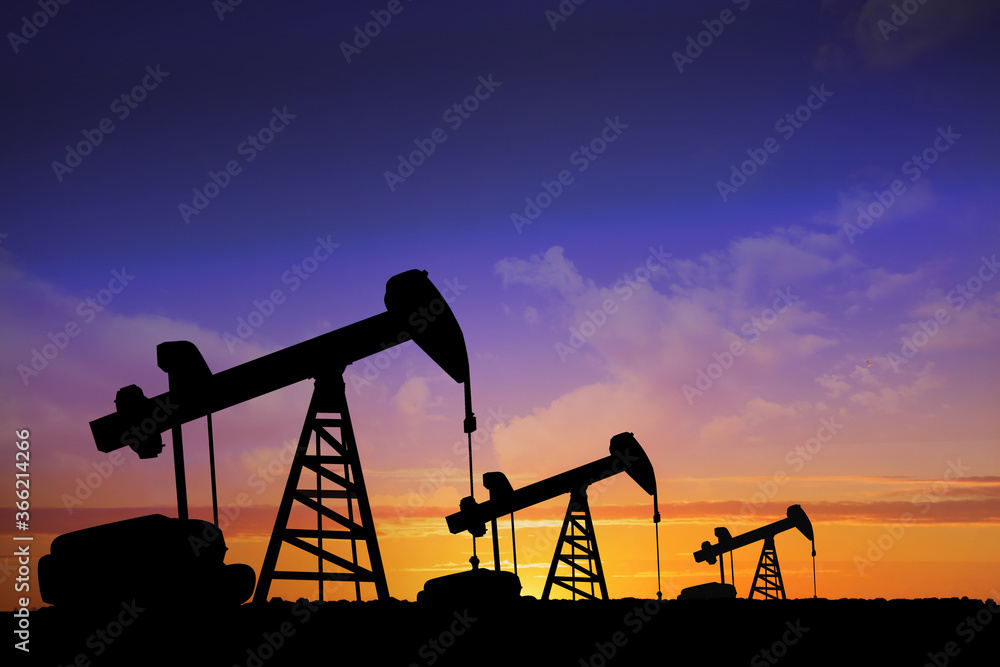 Silhouettes of crude oil pumps at sunset