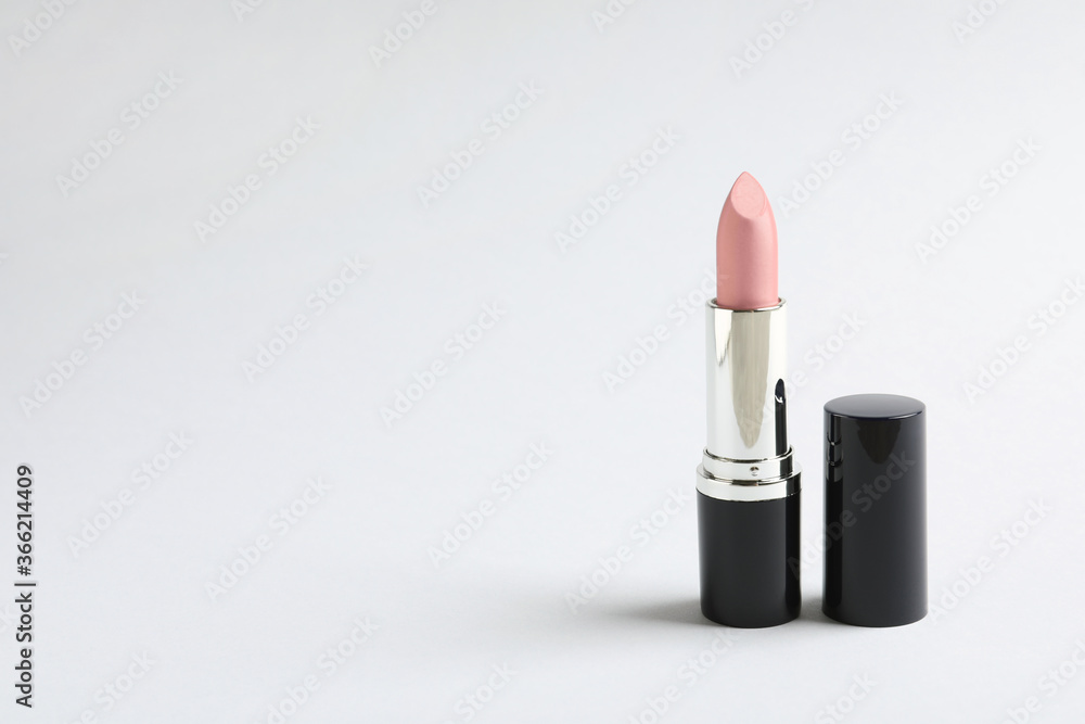 Pale pink lipstick on light background. Space for text Pale pink lipstick on light background. Space for text