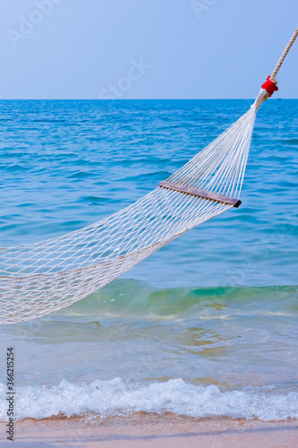 Romantic cozy hammock on the tropical beach by the sea. Peaceful seascape. Relax, travel concept, travelling.