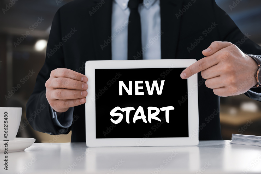 Obraz premium Fresh opportunities. Business owner holding tablet with text New Start at table, closeup
