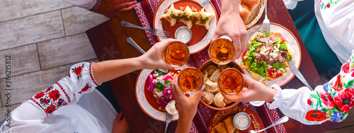 Ukrainian family in traditional closes has a dinner together. Ukrainian culture. Ukraine concept. Holiday concept.