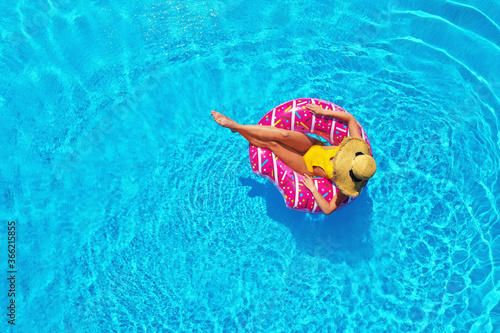 Young woman with inflatable ring in swimming pool  top view