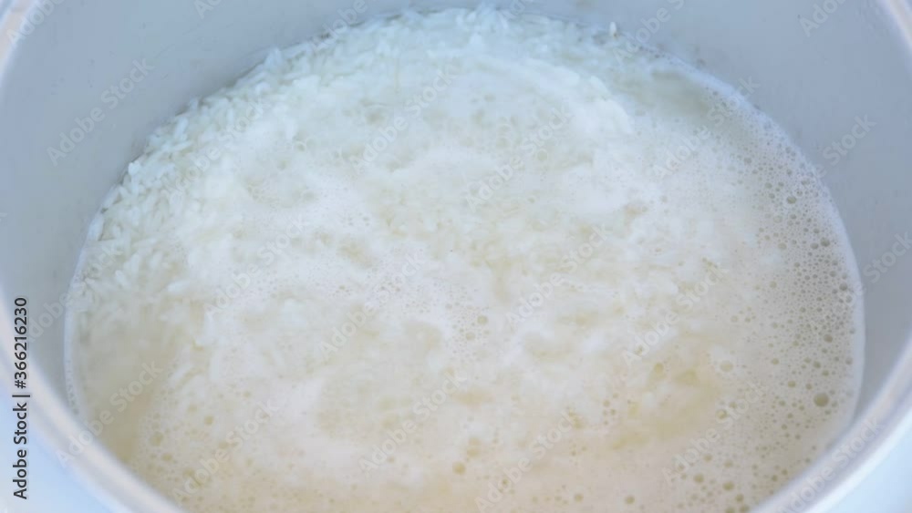 Steamed rice in boiling water in rice cooker Stock ビデオ Adobe Stock