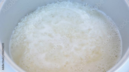Steamed rice in boiling water in rice cooker
