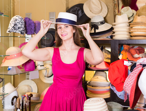 adult smiling english woman try on hatinator hat in shopping mall photo