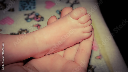 baby's leg in the palm of the mother's hand