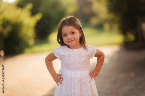 Portrait of happy smiled little girl in white dress