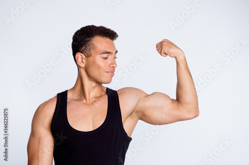 Close-up portrait of his he nice attractive sportive successful muscular cheery guy demonstrating looking at powerful muscles goal protein diet isolated over light gray pastel color background