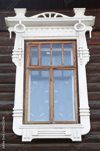 Richly decorated ornamental carved window and frame on old wooden house on Svoboda Street, 43 in Yaroslavl city, Russia. Russian traditional national folk style in wooden architecture. Yaroslavl sight photo