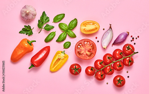 Tomato, basil, spices, bell chili pepper, garlic. Vegan diet food, creative composition on pink. Fresh basil, cherry tomatoes, bell pepper layout, cooking colorful concept, top view.