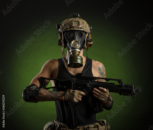 a man with a gun in a helmet on a dark background