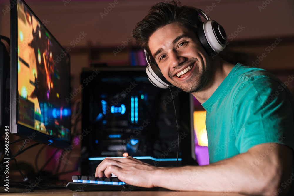 Image of caucasian happy man playing video game on computer Image of caucasian happy man playing video game on computer
