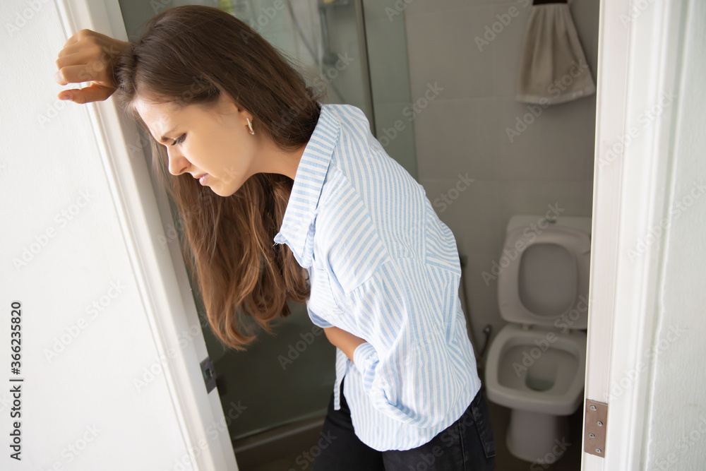 woman with diarrhea; sick woman suffering from diarrhea, stomachache, menstrual period cramp, abdominal pain, food poisoning, gastritis, constipation; caucasian young adult woman health care model