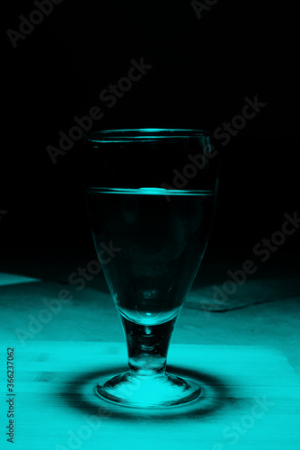 wine glass with wine on wooden table with black background.