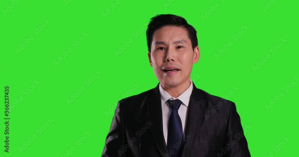 Asian businessman looking in camera and talking on a Green Screen, Chroma Key. Asian businessman looking in camera and talking on a Green Screen, Chroma Key.