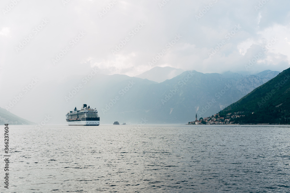 The cruise liner sails near the city of Perast and the islands in Montenegro.