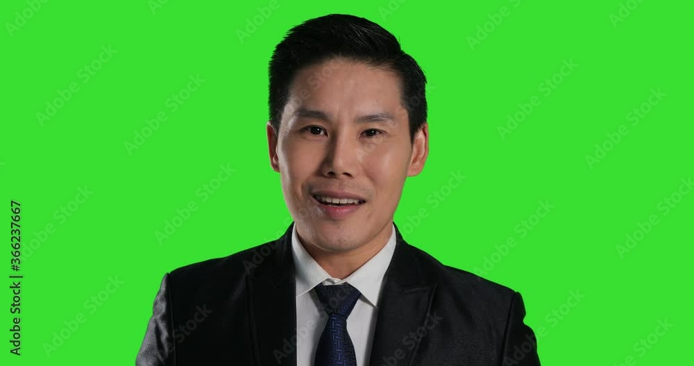 Asian businessman looking in camera and talking on a Green Screen, Chroma Key. Asian businessman looking in camera and talking on a Green Screen, Chroma Key.