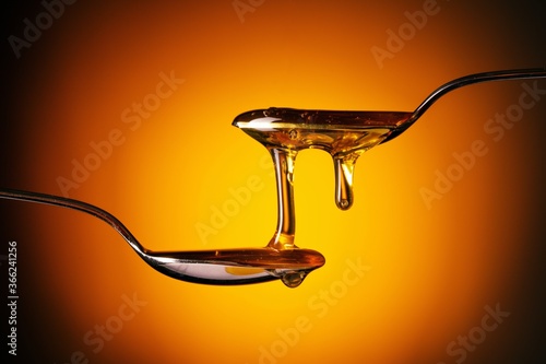 Organic honey flowing from the spoon