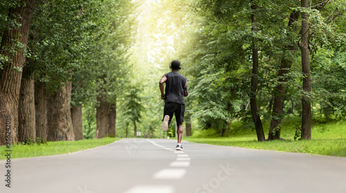 Rear view of black jogger exercising at park