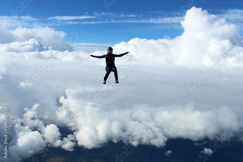 Skydiving. A skydiver is flying above white clouds. © Sky Antonio