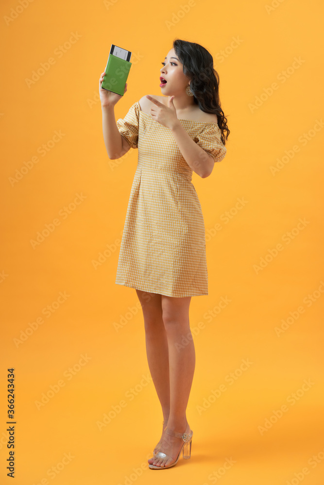 Tourist woman on vacation holding passport very happy pointing with hand and finger Tourist woman on vacation holding passport very happy pointing with hand and finger