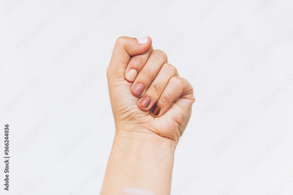 Female fist protesting on white background. Female hand raised up with different nails colors, skin and race diversity. Women rights concept. Stop racism Female fist protesting on white background. Female hand raised up with different nails colors, skin and race diversity. Women rights concept. Stop racism