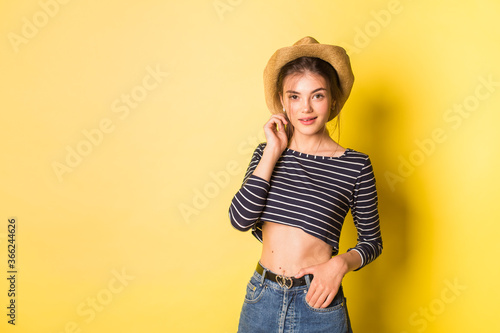 Portrait hipster beauty girl in hat on yellow background