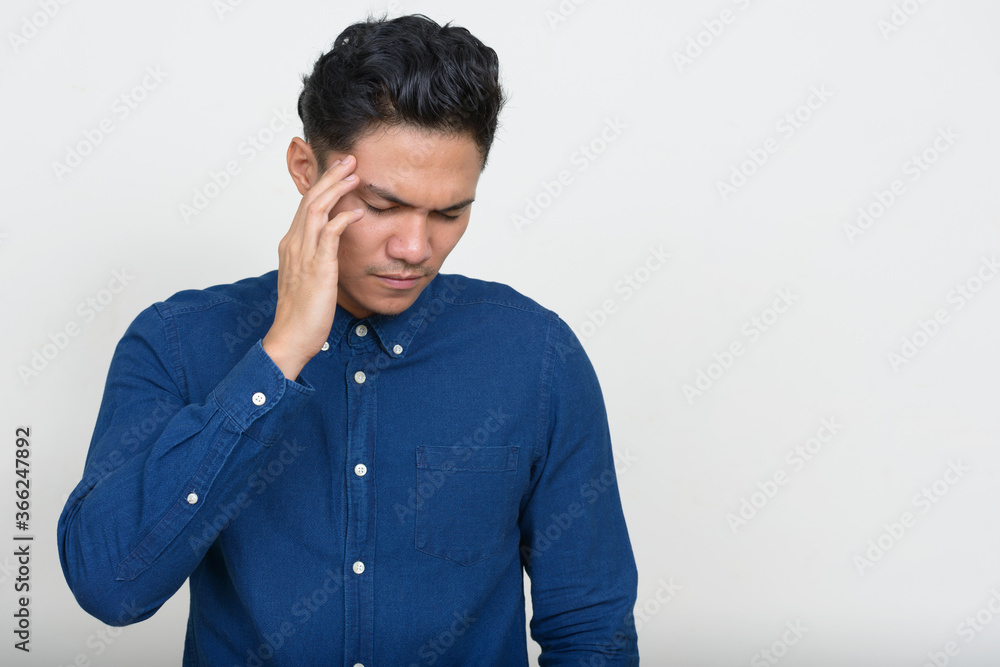 Portrait of stressed Asian businessman having headache Portrait of stressed Asian businessman having headache