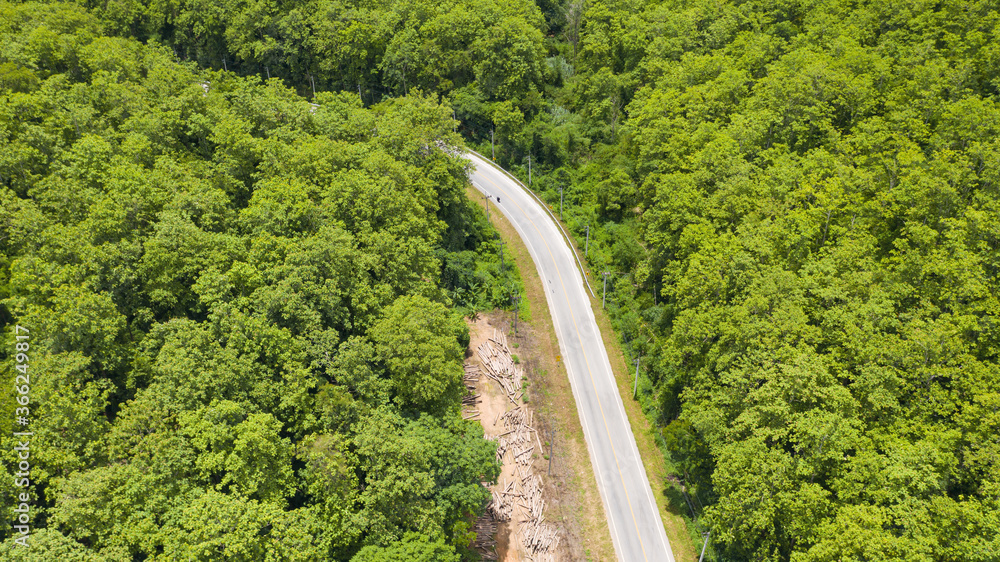 Aerial top view of a provincial road passing through a forest background