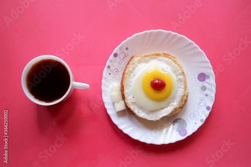 Homemade Fried Egg on burger and cup of Coffee for Breakfast,cherry top view, 
