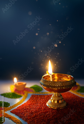 Happy Diwali, Glittering diya oil lamp against dark background with copy space photo