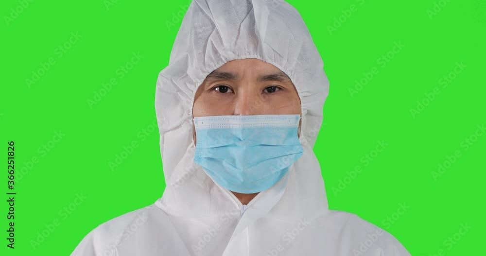 Close up shot of a male doctor or healthcare worker wearing personal protective kit while working at green screen. Close up shot of a male doctor or healthcare worker wearing personal protective kit while working at green screen.