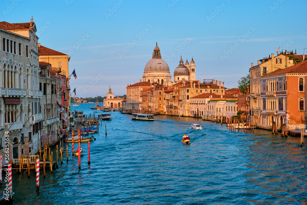 Panorama of Venice Grand Canal with gondola boats and Santa Maria della Salute church on sunset from Ponte dell'Accademia bridge. Venice, Italy