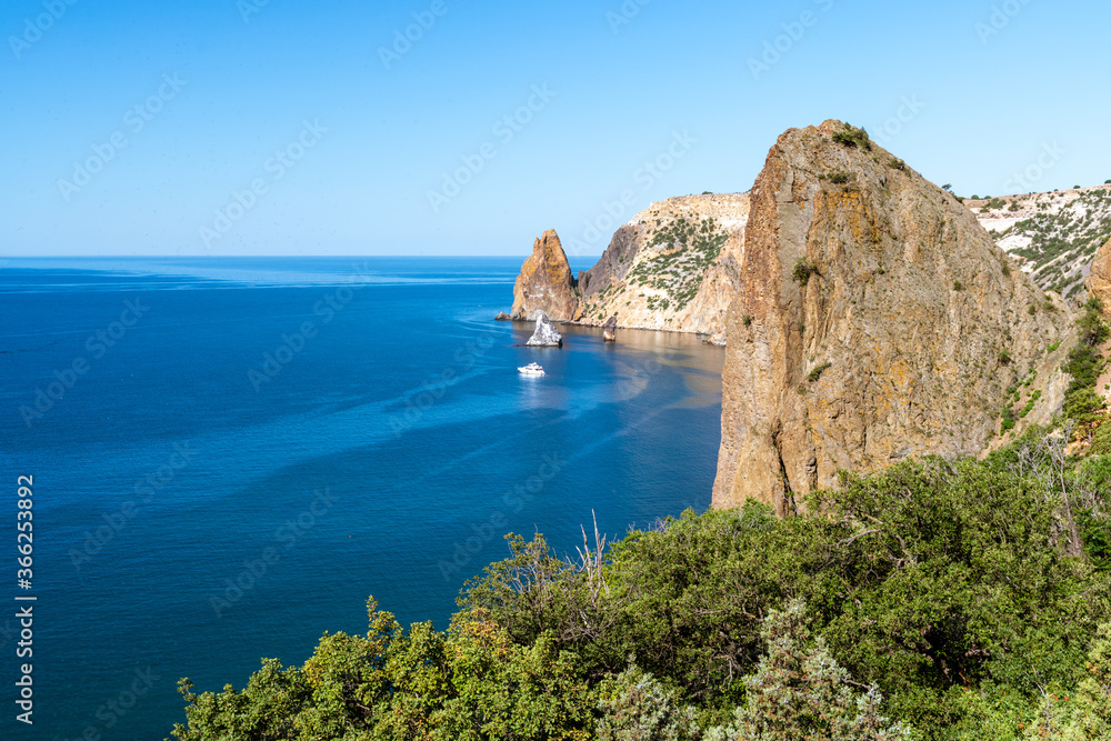 Fototapeta premium View from above on the coast of Fiolent, in the bay can be seen a rock in the sea and Inflatable round plateun fon holiday by the sea.