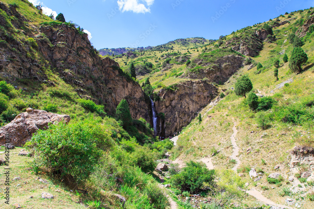 Kegeti waterfall. Background for tourism and travel. Summer landscape. Kegeti Gorge, Kyrgyzstan. Kegeti waterfall. Background for tourism and travel. Summer landscape. Kegeti Gorge, Kyrgyzstan.