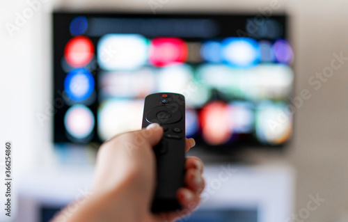 Hand holds remote control from smart TV