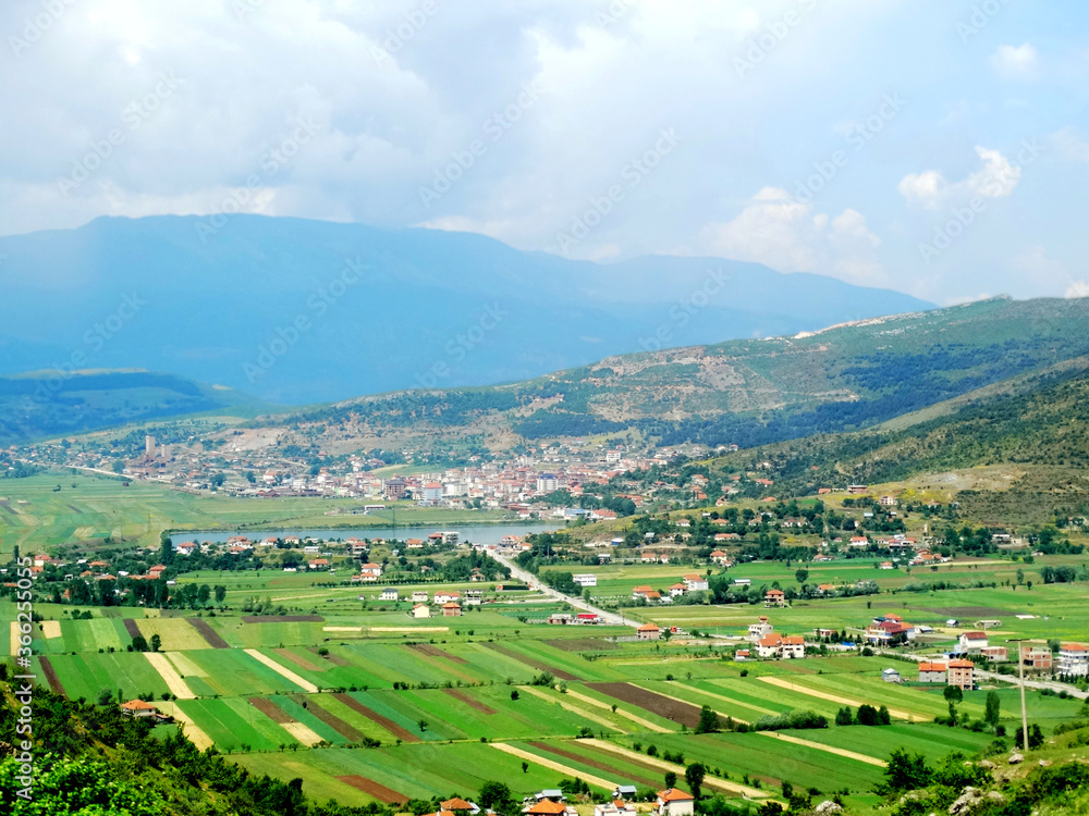 Natural countryside landscape with agricultural crops in valley field beside mountains. Transportation way from Macedonia to Albania.