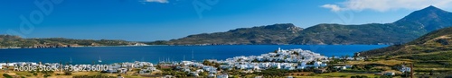 View of Plaka village with traditional Greek church and white painted houses and ocean coast. Milos island, Greece