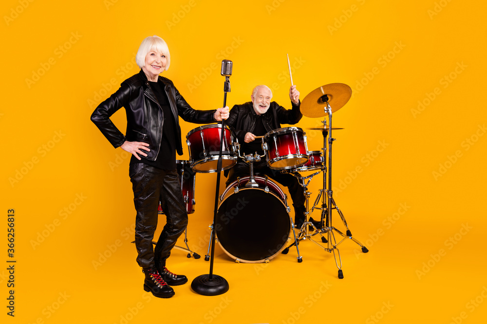 Fototapeta premium Portrait of his he her she nice attractive cheerful cheery trendy fashionable grey-haired couple giving live concert performing isolated over bright vivid shine vibrant yellow color background