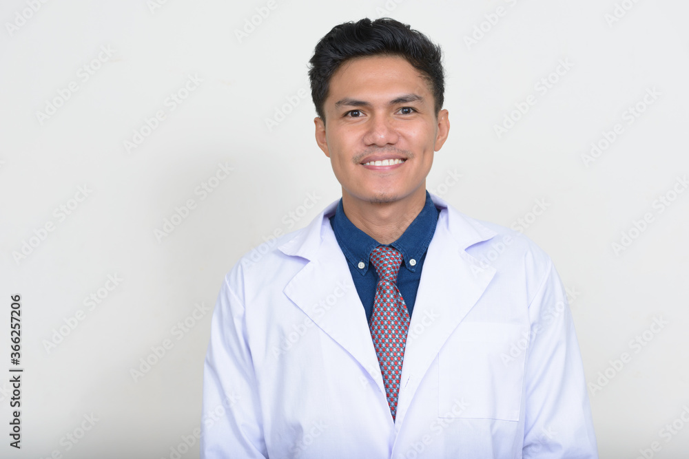 Portrait of happy handsome Asian man doctor smiling Portrait of happy handsome Asian man doctor smiling