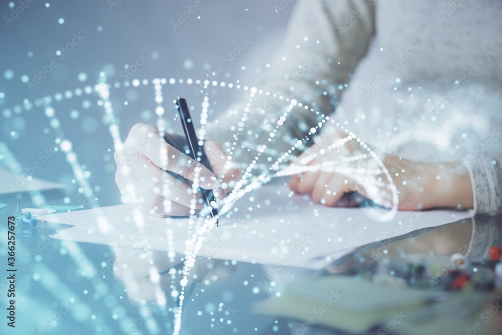 DNA theme hologram over woman's hands writing background. Concept of education. Double exposure DNA theme hologram over woman's hands writing background. Concept of education. Double exposure