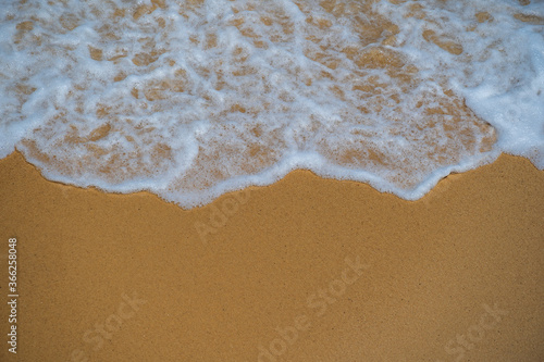 Seashore texture, line water foam over clean sand. Troical beach and sea water, close up