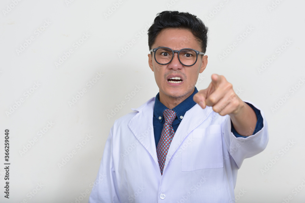 Portrait of angry Asian man doctor with eyeglasses pointing at camera Portrait of angry Asian man doctor with eyeglasses pointing at camera