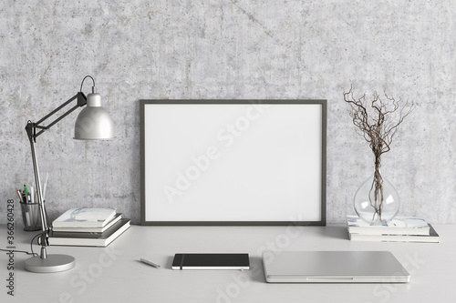 Horizontal poster frame mockup on the white table of home studio workspace with concrete wall. Front view, clipping path around poster picture.