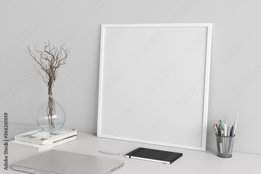 Square poster frame mockup on the white table of home studio workspace with white wall. Side view, clipping path around poster picture. Square poster frame mockup on the white table of home studio workspace with white wall. Side view, clipping path around poster picture.